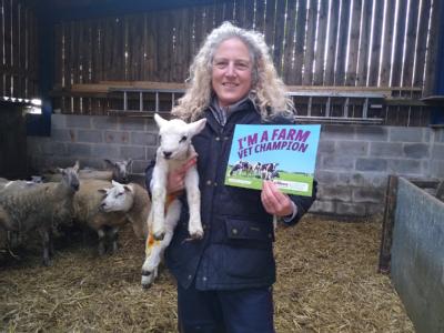 Fiona Lovatt holding a lamb and a poster